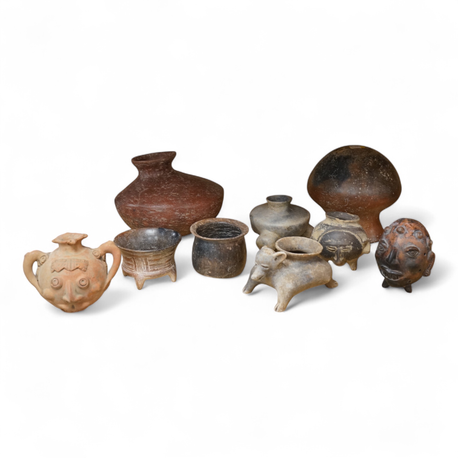 A collection of various South American vessels some in the form of grotesque heads, largest 24cm wide